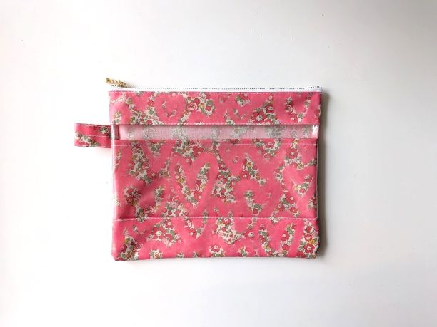 仕切り付きL-3　22×18　クリアポーチ　ベッツィアングラフィティ　リバティ　ラミナート　♡リバティの象徴的な花柄の上にスプレーで描かれたハートが並べられ、魅力的デザインが誕生しました